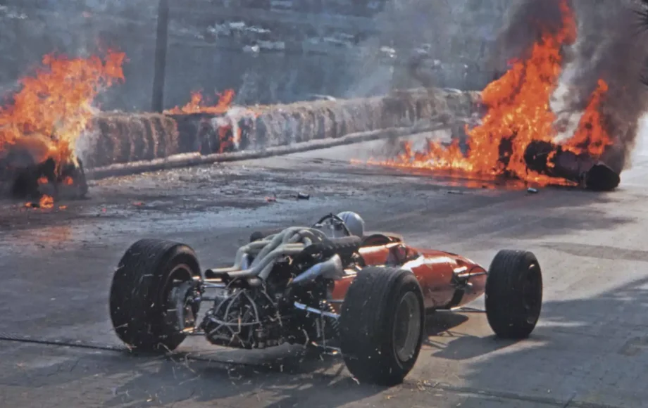Chris Amon avoids burning wreckage of his teammate Lorenzo Bandini's Ferrari 312 at the 1967 Monaco GP